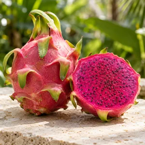 A whole red dragon fruit beside one cut open to show magenta flesh