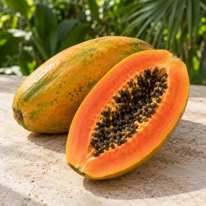 A whole papaya beside a halved papaya showing orange flesh and dark seeds
